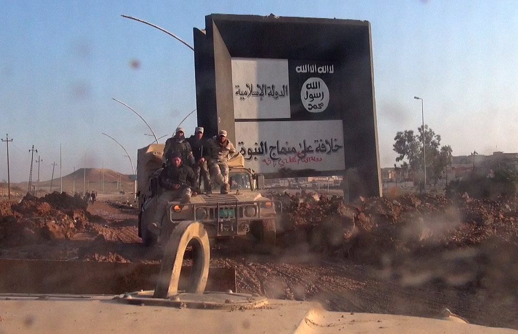 Иракские военные позируют на фоне символов ИГИЛ, январь 2017.