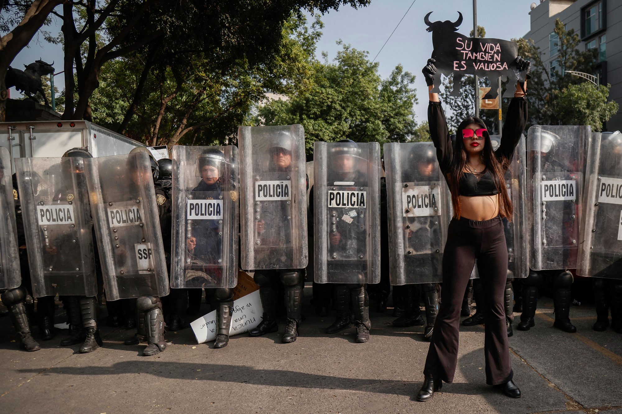 Протестувальниця тримає плакат перед поліцією під час акції проти кориди біля площі Пласа-де-Торос-Мексико в Мехіко, 28 січня 2024 року. Активісти протестували проти відновлення кориди в Мехіко після того, як Верховний суд скасував попередню заборону. Фото: RODRIGO OROPEZA/AFP via Getty Images